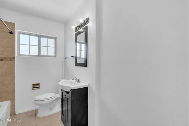 a bathroom with a toilet a sink and mirror