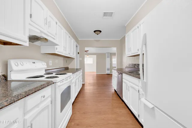 a large kitchen with stainless steel appliances granite countertop a stove and a sink