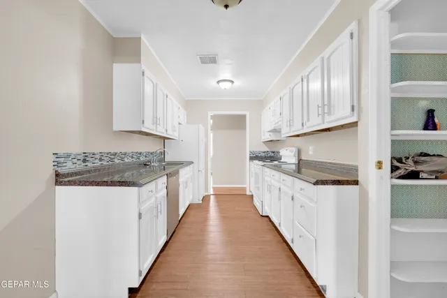 a kitchen with granite countertop a sink and cabinets