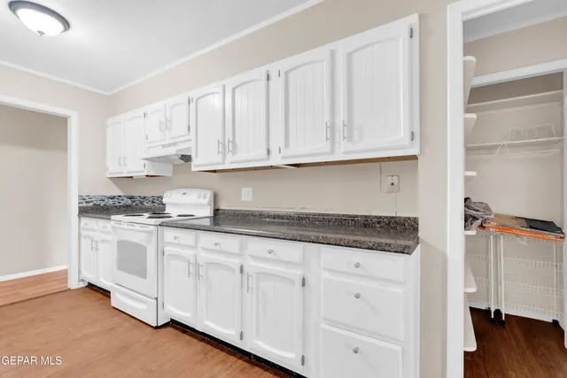 a kitchen with granite countertop white cabinets and sink