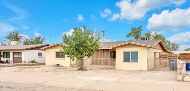 a white house with a large tree in front of it