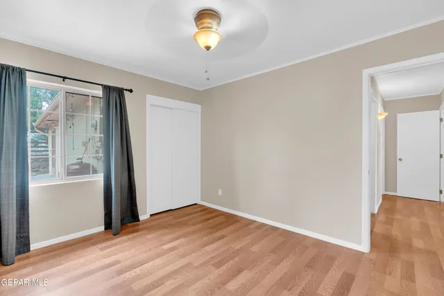 a view of empty room with wooden floor