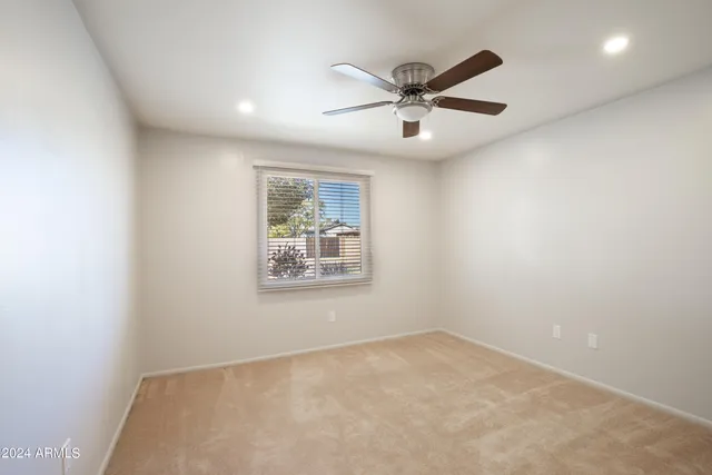 en empty room with windows and ceiling fan