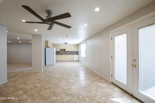 a view of a big room with a ceiling fan and windows