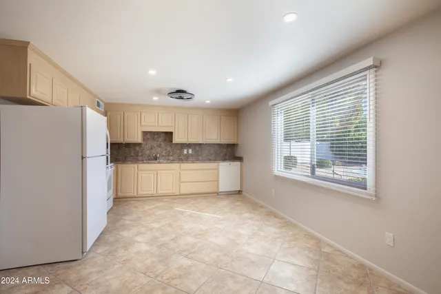a kitchen with refrigerator cabinets and wooden floor