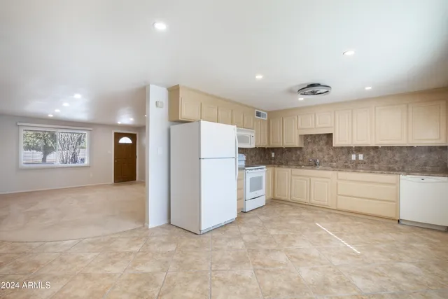 a kitchen with granite countertop white cabinets and white appliances