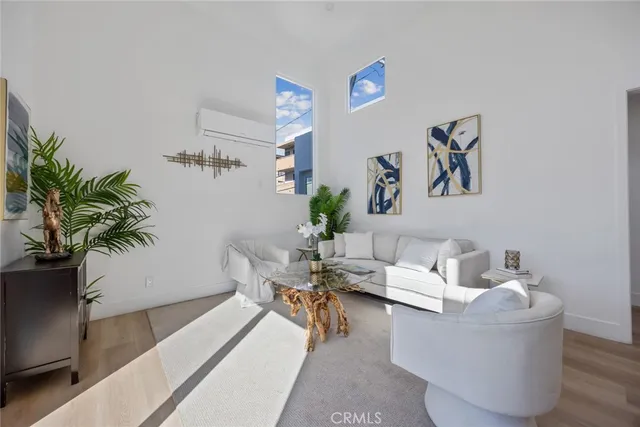 a living room with furniture kitchen view and a potted plant
