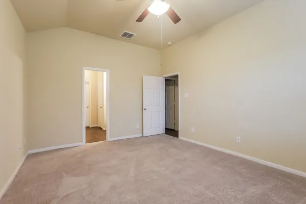 an empty room with a ceiling fan and a window