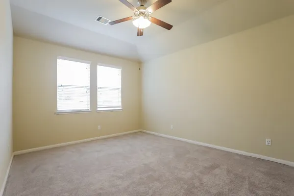 an empty room with a window and a fan