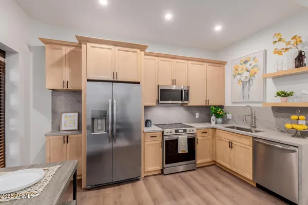 a kitchen with stainless steel appliances granite countertop a sink a stove and a refrigerator