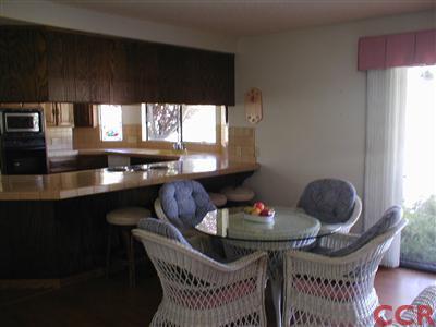 5780 Robin Court Santa Maria, CA 93455 - Photo 13 of 15 a kitchen with granite countertop a table chairs stove a dining table and chairs