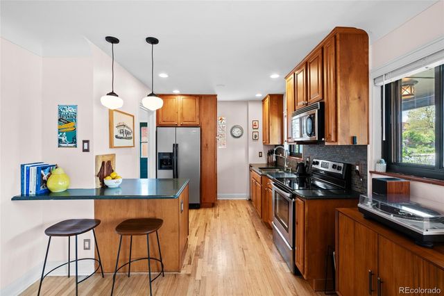 a kitchen with stainless steel appliances granite countertop a stove a sink and a microwave