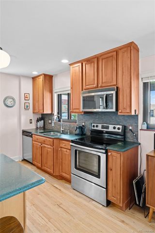 a kitchen with stainless steel appliances granite countertop a stove a sink and a microwave