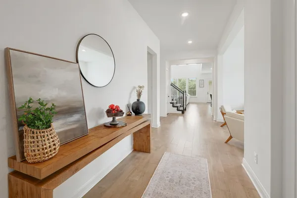 a hallway with a potted plant on the kitchen counter top and wooden floor