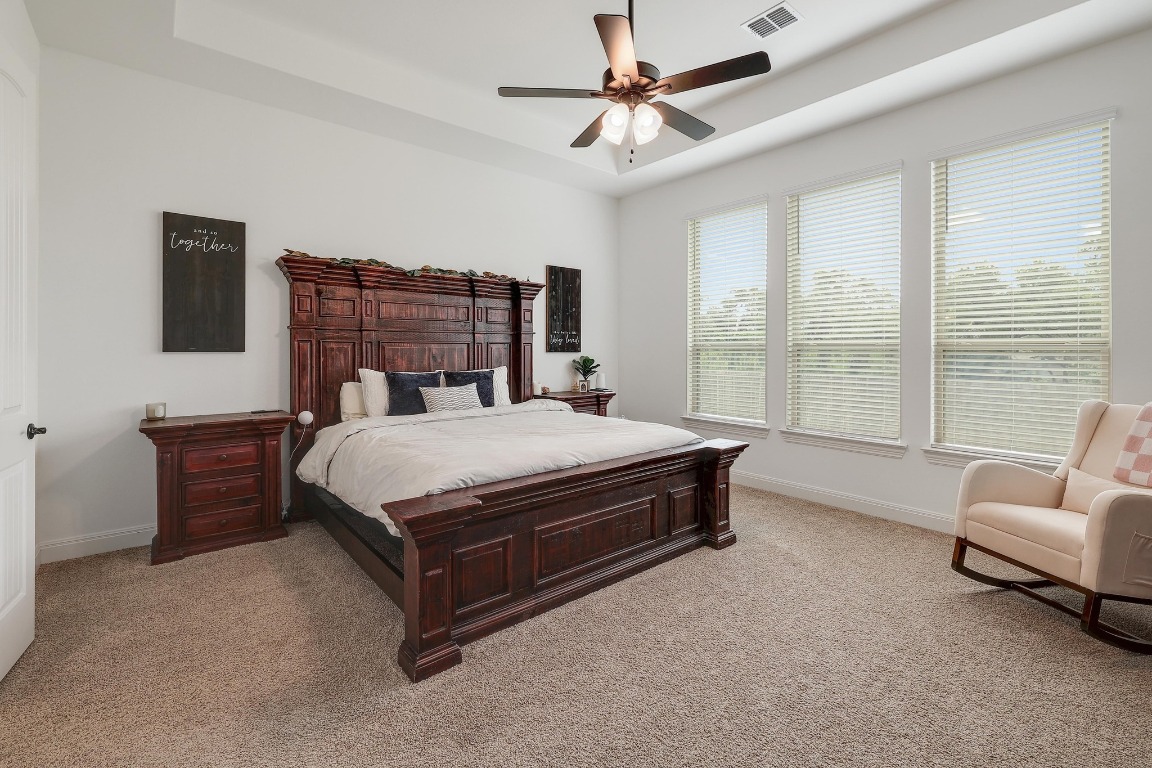 100 Garden Rose Pass Georgetown, TX 78628 - Photo 18 of 39 a spacious bedroom with a bed couch and a large window