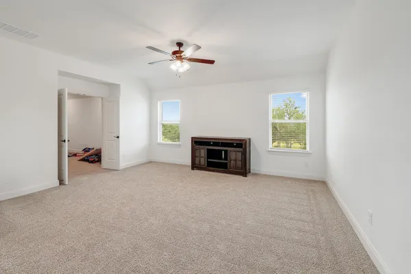 an empty room with windows and fireplace