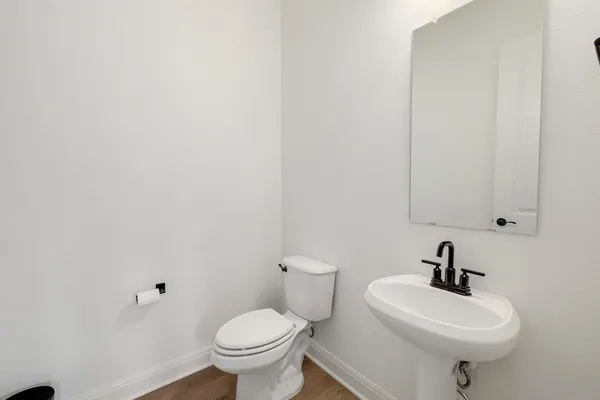 a bathroom with a sink a toilet and a mirror