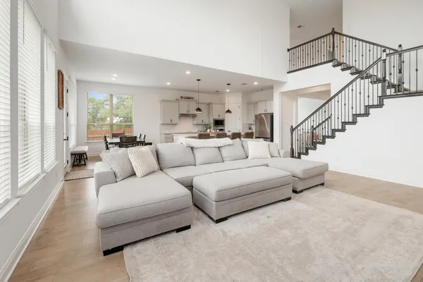 a living room with furniture white walls and a large window