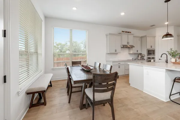 a kitchen with kitchen island a dining table and chairs