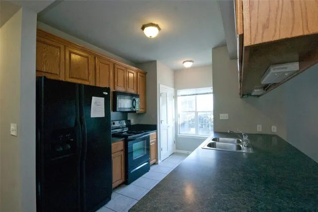 a kitchen with granite countertop a stove and a wooden floor