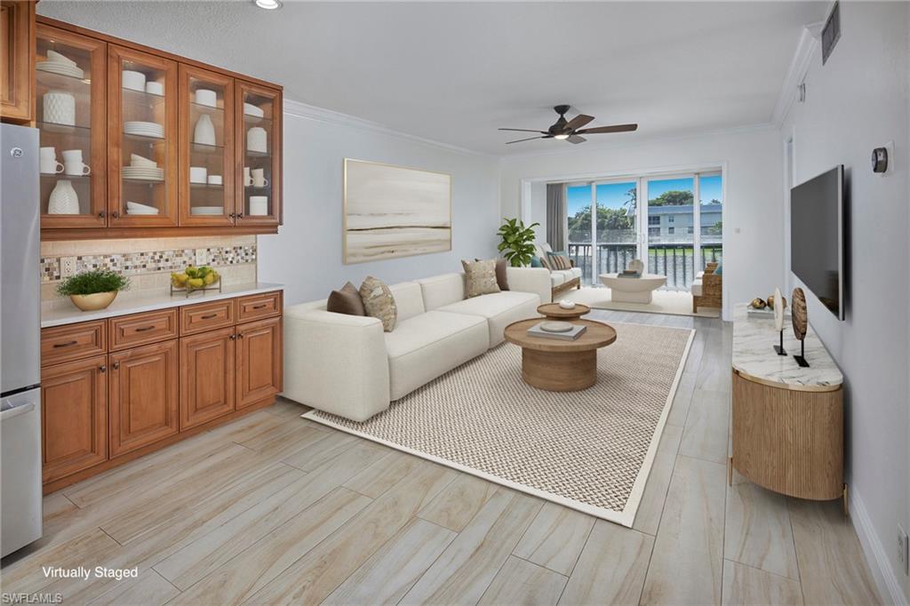 3100 Binnacle Drive, Unit 305 Naples, FL 34103 - Photo 4 of 12 a living room with furniture and a flat screen tv