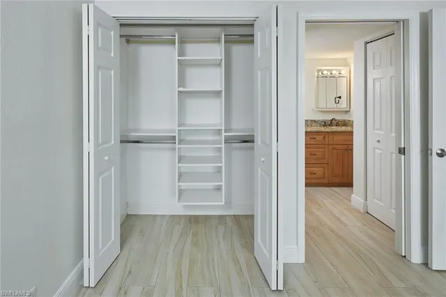 a view of walk in closet with wooden floor
