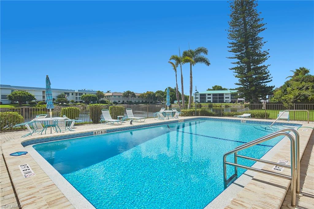 3100 Binnacle Drive, Unit 305 Naples, FL 34103 - Photo 10 of 12 a view of a swimming pool with a lounge chairs