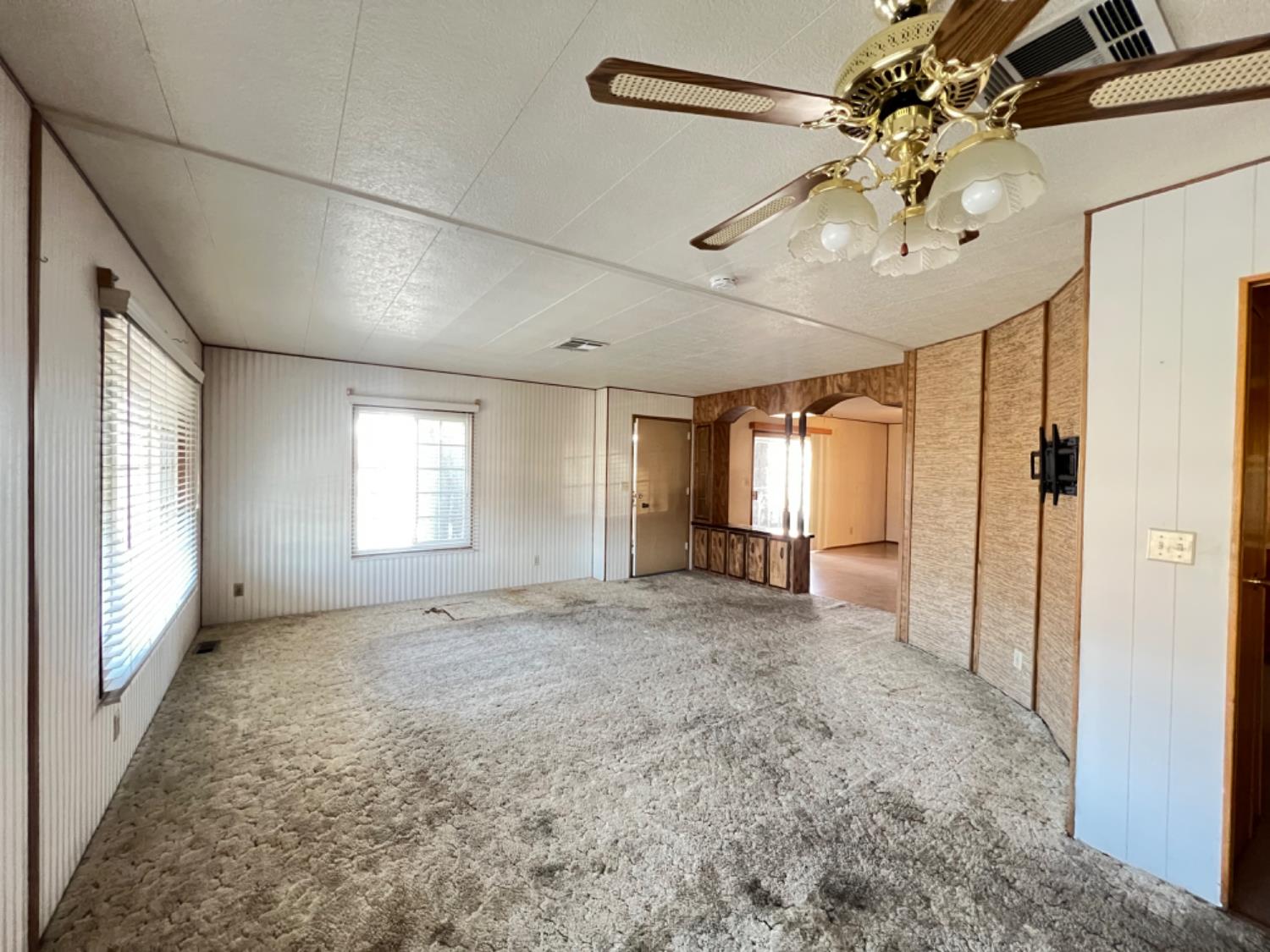 144 Gumtree Drive Rancho Cordova, CA 95670 - Photo 4 of 21 en empty room with windows and ceiling fan