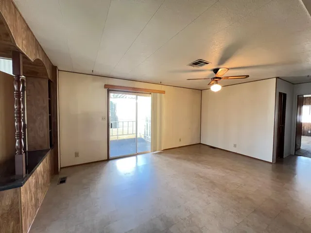 a view of a livingroom with a ceiling fan and window