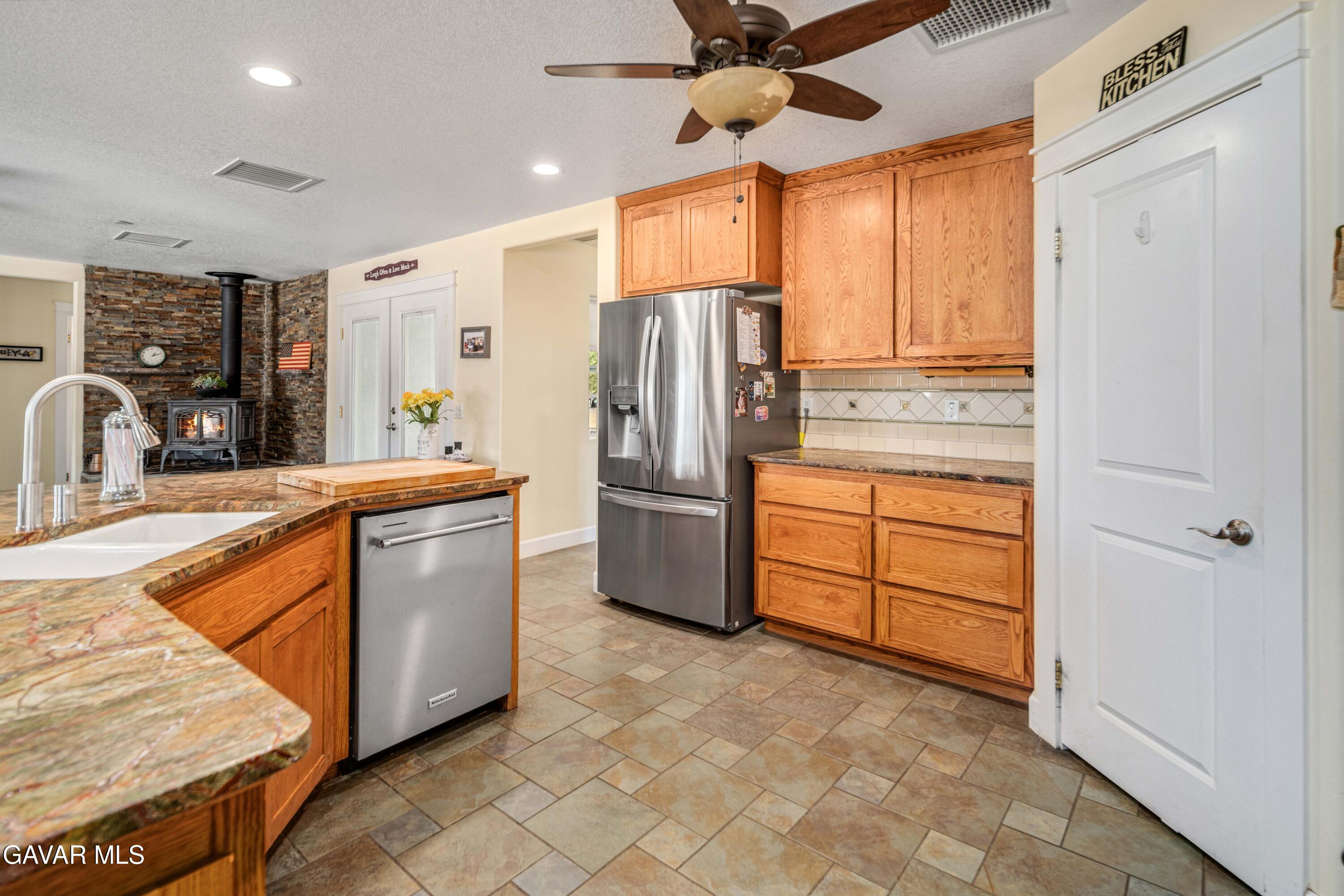 46472 Kings Canyon Road Lancaster, CA 93536 - Photo 14 of 33 a kitchen with stainless steel appliances granite countertop a refrigerator a sink and dishwasher