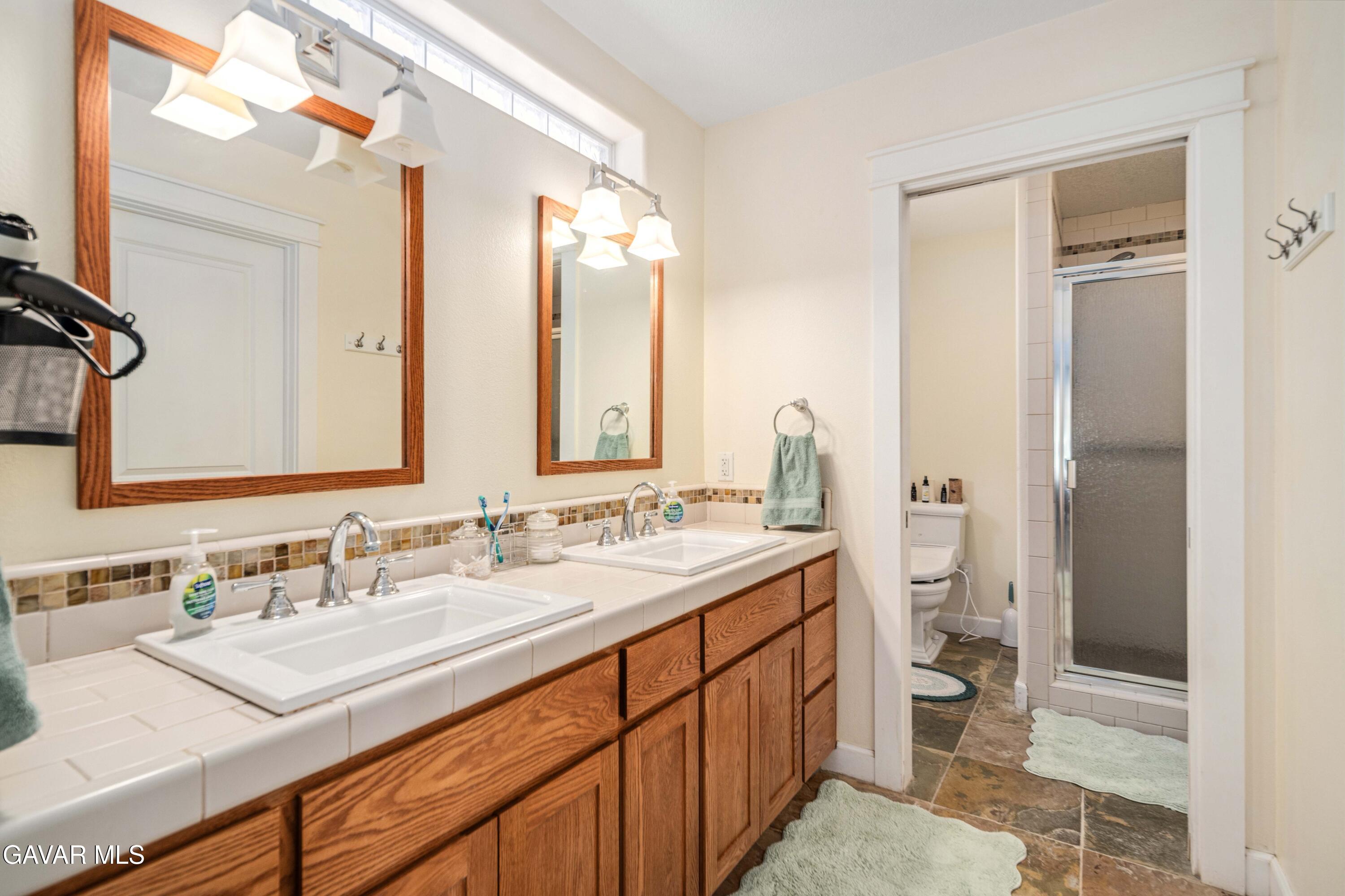 46472 Kings Canyon Road Lancaster, CA 93536 - Photo 19 of 33 a bathroom with a sink a toilet and shower