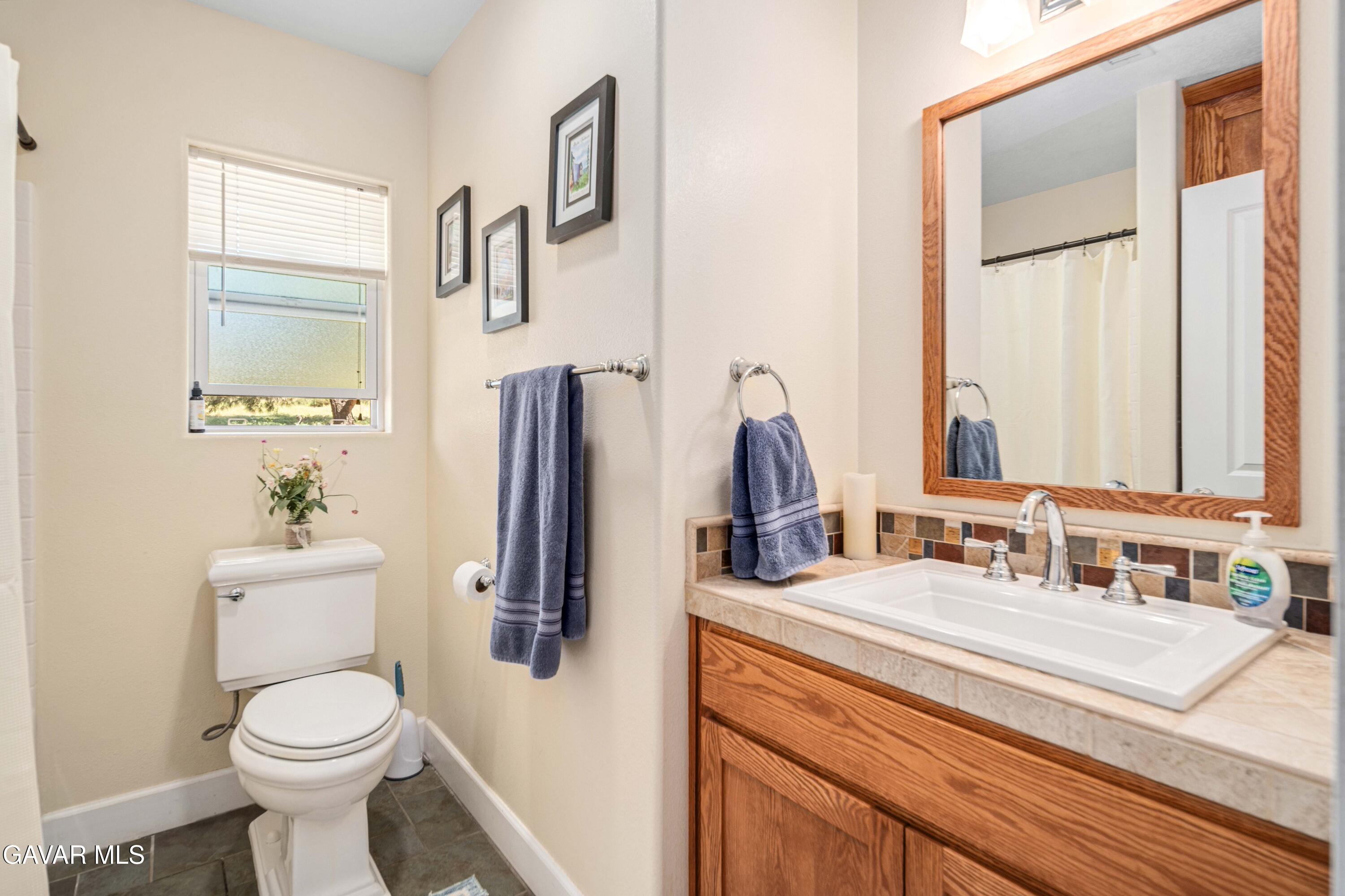 46472 Kings Canyon Road Lancaster, CA 93536 - Photo 24 of 33 a bathroom with a toilet sink and mirror
