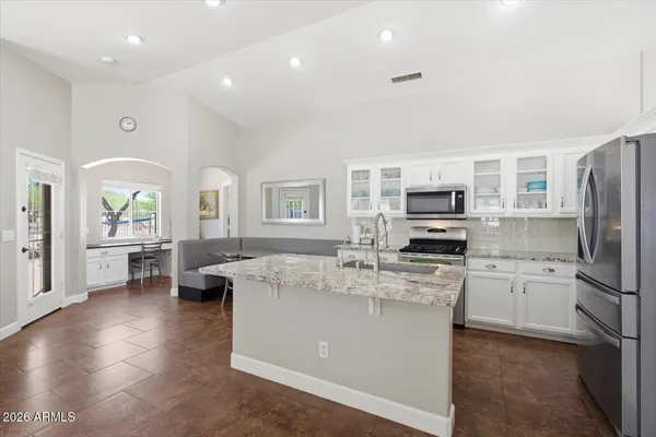 a kitchen with stainless steel appliances granite countertop a sink stove and refrigerator