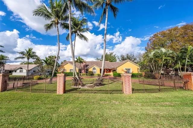 a front view of a house with a yard and potted plants