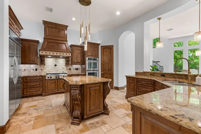 a kitchen island with stainless steel appliances kitchen island granite countertop a table and chairs in it