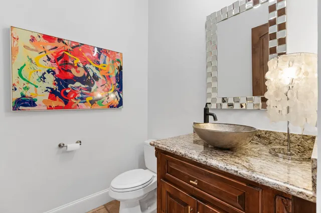 a bathroom with a granite countertop sink toilet mirror and bathtub