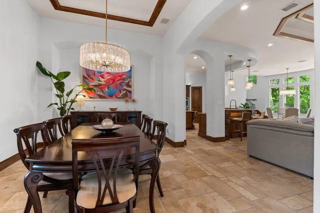 a view of a dining room with furniture a chandelier and wooden floor