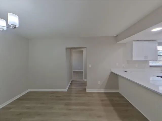 a view of a kitchen with wooden floor and electronic appliances