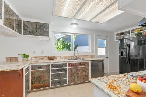 a kitchen with stainless steel appliances kitchen island granite countertop a stove a sink a dining table and chairs with wooden floor