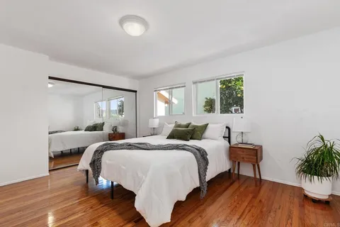 a bedroom with a bed and wooden floor