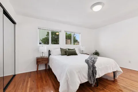 a bedroom with a large bed and a painting on the wall