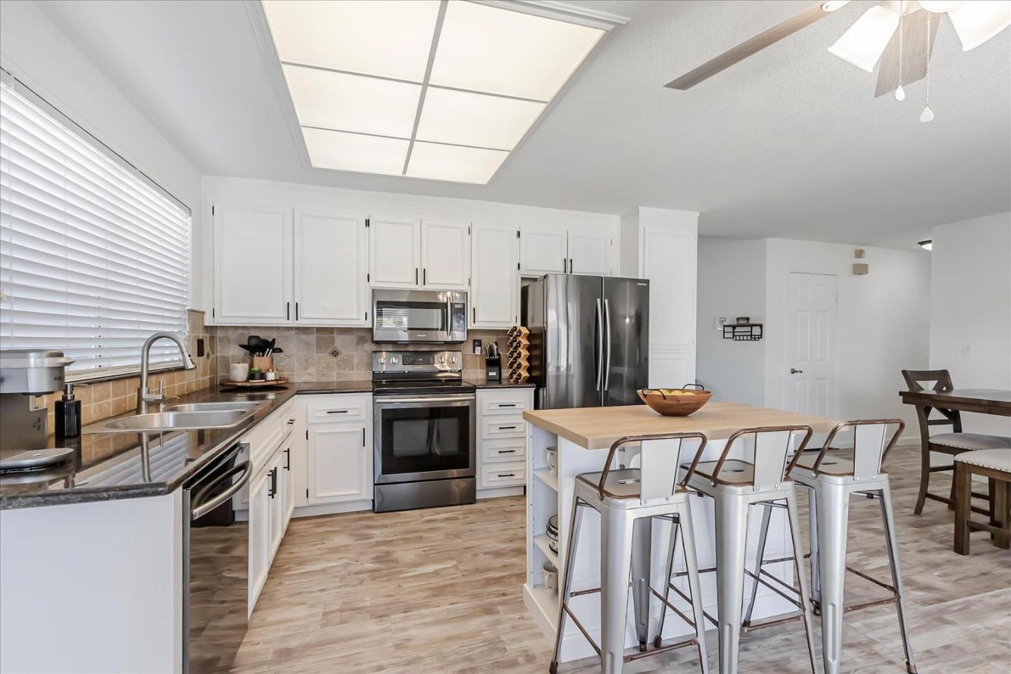 5075 Eppling Lane San Jose, CA 95111 - Photo 10 of 60 a kitchen with stainless steel appliances granite countertop a kitchen island hardwood floor sink stove dining table and chairs