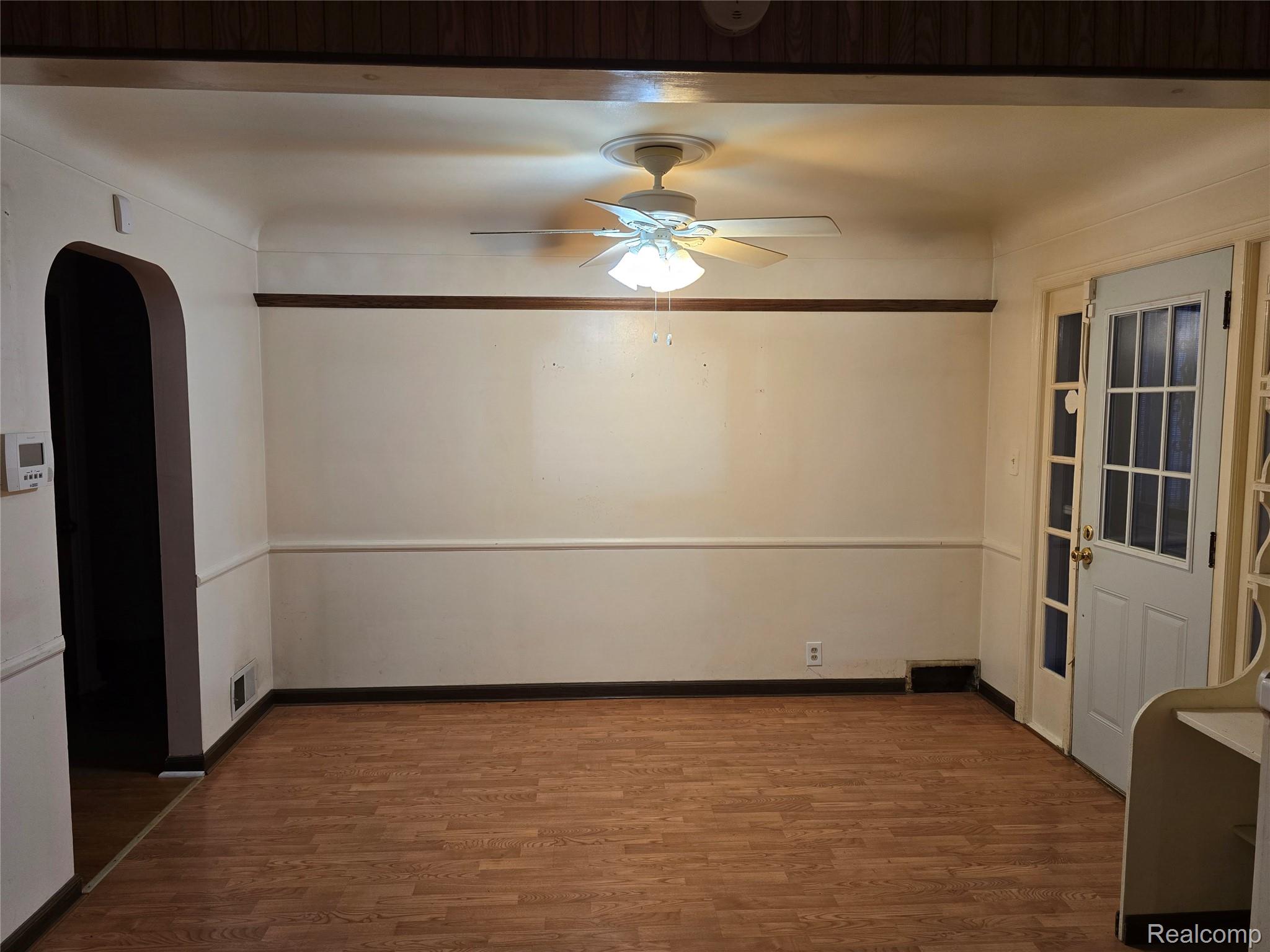 803 Commonwealth Avenue Flint, MI 48503 - Photo 8 of 15 Unfurnished room with arched walkways, dark wood finished floors, and ceiling fan