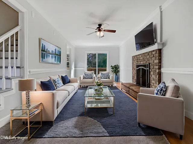 a living room with furniture a fireplace and a flat screen tv