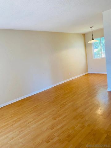 a kitchen with a wooden floor and a large window