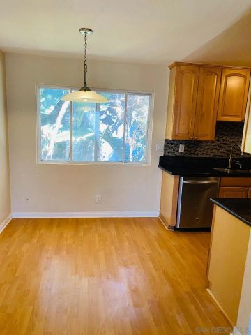 a kitchen with kitchen island granite countertop wooden cabinets and a sink