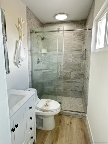 a bathroom with a shower a toilet and a sink
