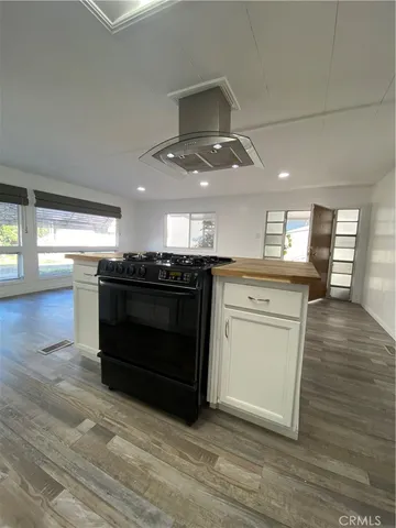 a kitchen with stainless steel appliances granite countertop a stove and a wooden floors