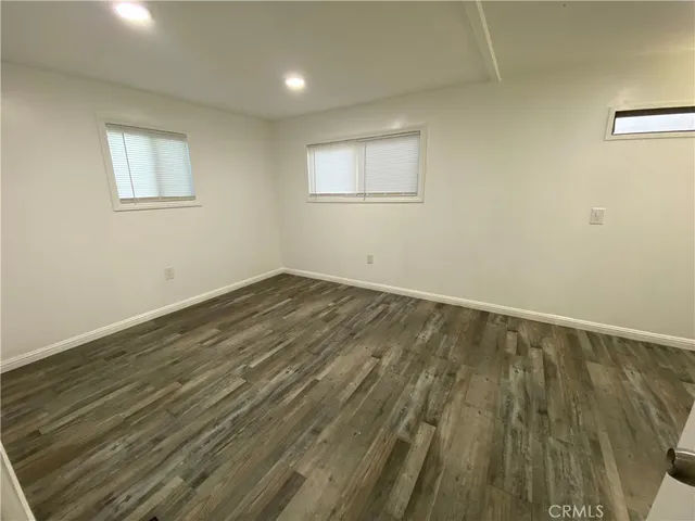 a view of a room with wooden floor and windows