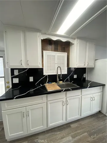 a kitchen with granite countertop a sink and cabinets